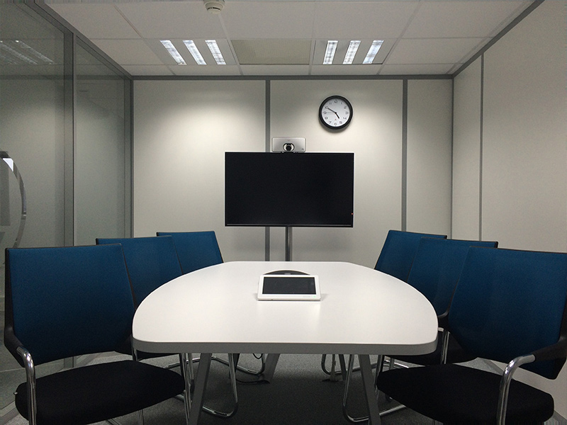 Modern conference room with gray paneled walls and blue chairs, featuring commercial painting in Canton by Frank Kaye Painting.