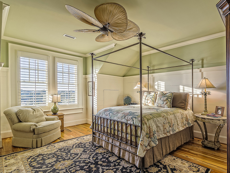 Interior painting done by Frank Kaye Painting Company Bedroom with green painted walls, a bed, sofa, fan and decorative rug.